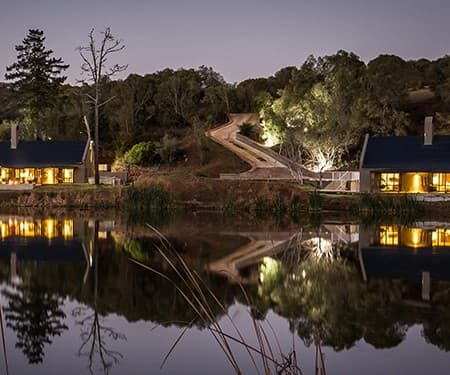 Waterside villas reflected at dusk at Botlierskop Private Game Reserve