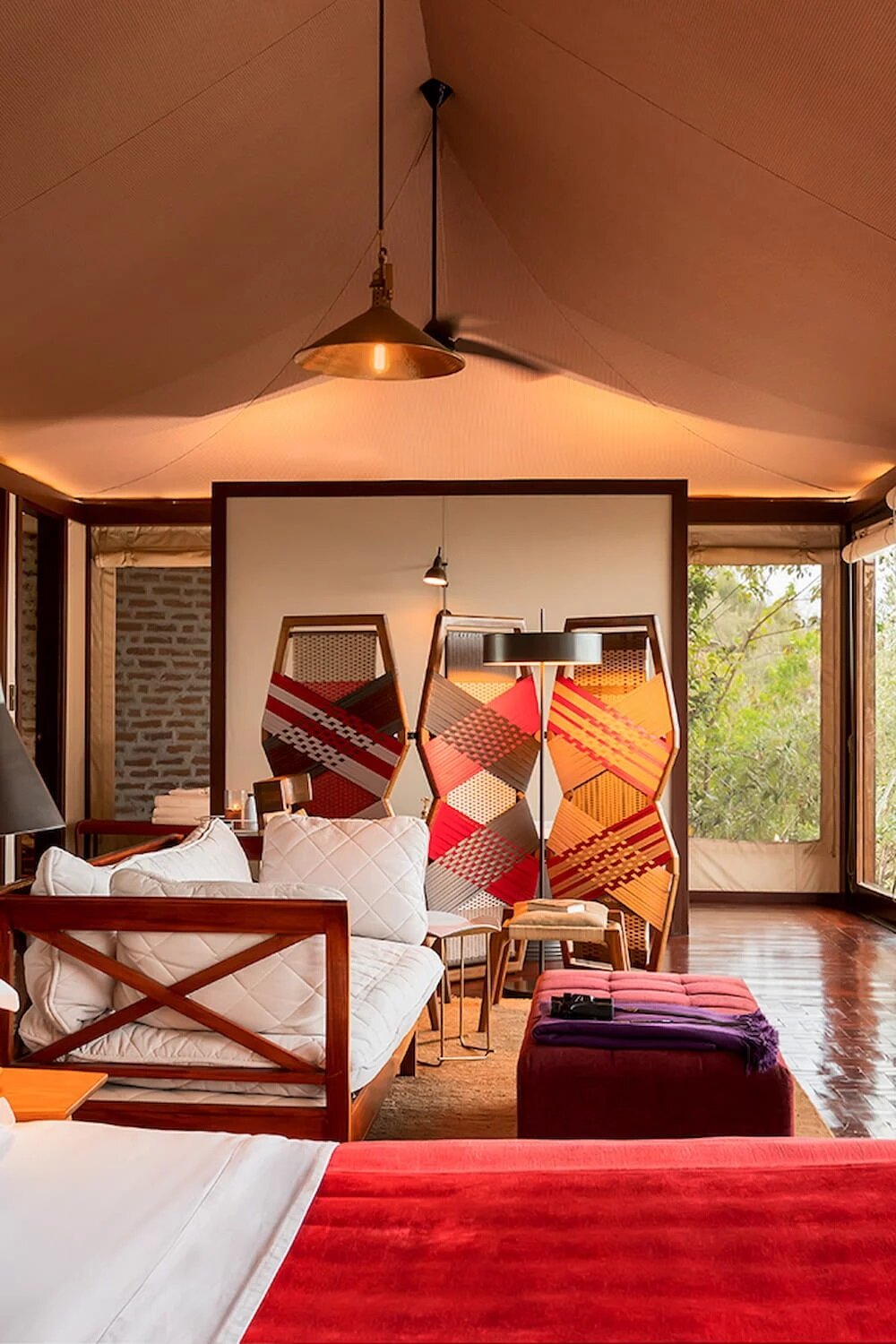 Glass-fronted tented suite bedroom looking over the Mara Triangle at Angama Mara