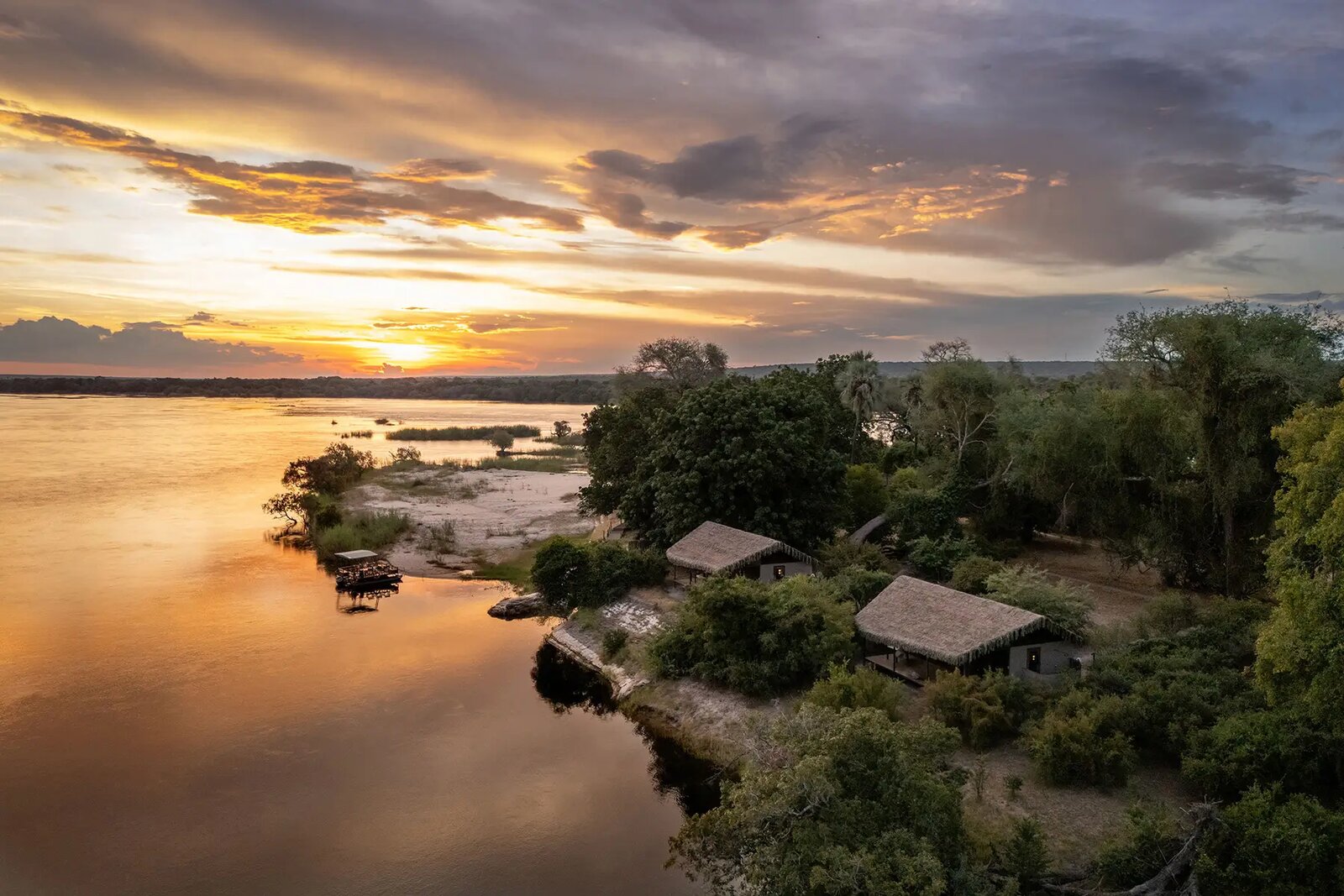 Chundu Island tented suites on a private island in the Zambezi River at golden hour